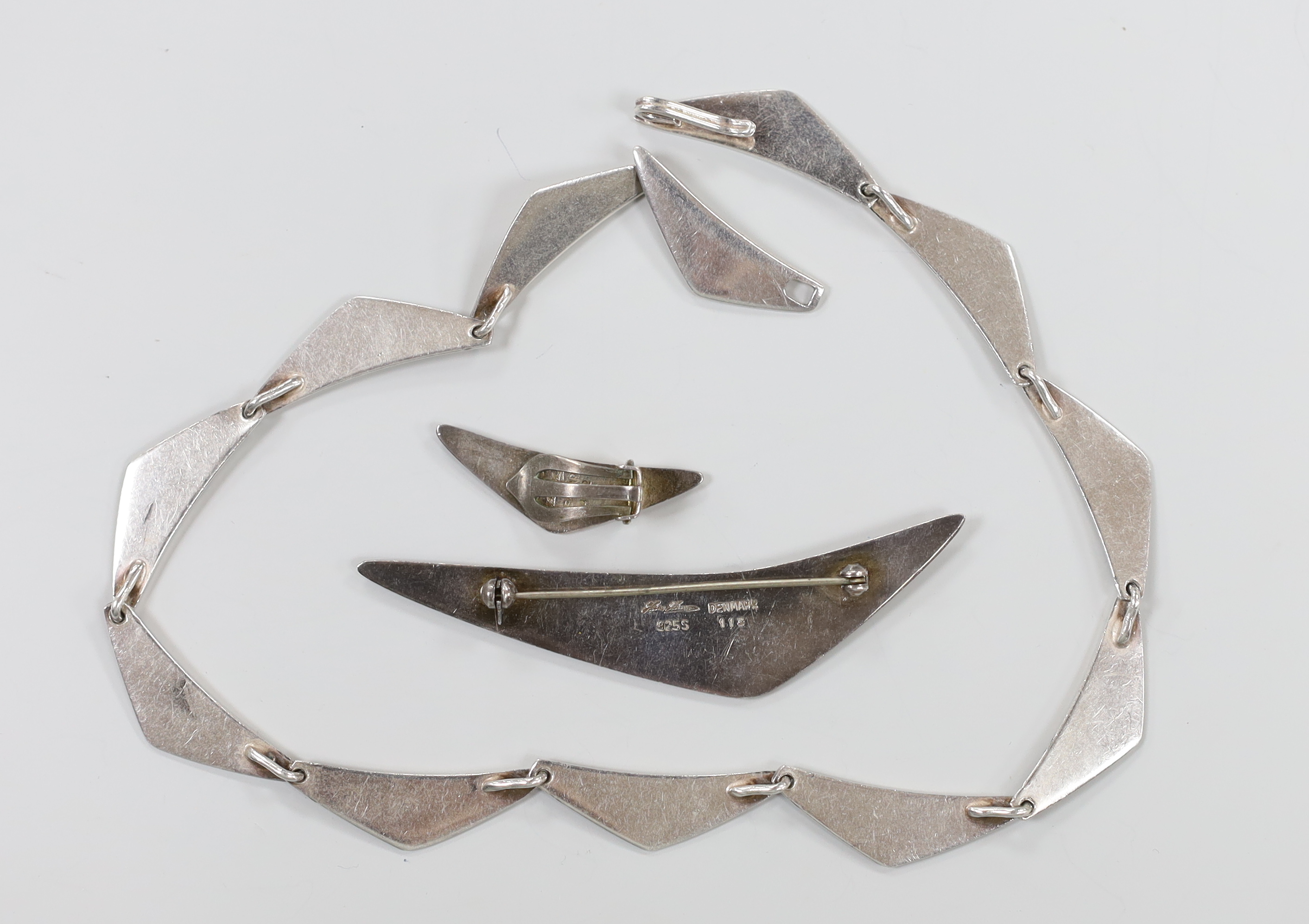 A 20th century Danish sterling necklace, by Hans Hansen design no. 315, 35.5cm, together with a similar brooch, design no. 113 and single ear clip, design no. 432.